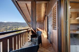 a balcony with chairs and a view of the mountains at Apartment Holzsuite in Fondo