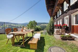 a picnic table and bench in the grass next to a building at Black Forest Woods in Bernau im Schwarzwald