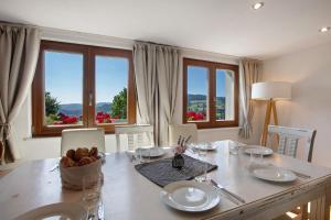 a dining room with a table and chairs and windows at Black Forest Woods in Bernau im Schwarzwald