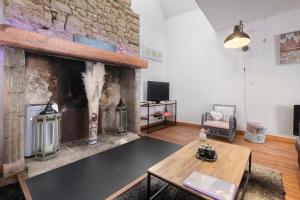 a living room with a fireplace and a table at La Perle Rosée in Azerat