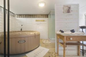 a room with a large tub and a table at La Perle Rosée in Azerat +21 photos