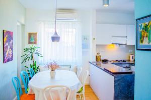 kuchnia ze stołem, białym stołem i krzesłami w obiekcie Maestro Duplex Istarska Apartment w Splicie