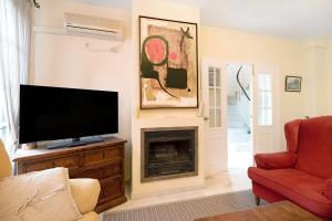 a living room with a television and a fireplace at Espiritu Santo Velero 54 in Sanlúcar de Barrameda