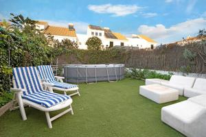 a patio with two chairs and a couch and a table at Espiritu Santo Velero 54 in Sanlúcar de Barrameda