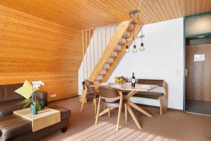 a dining room with a table and a staircase at Maisonette auf 1000m mit Sauna in Schönwald