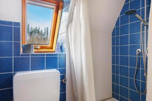 a blue tiled bathroom with a toilet and a window at Maisonette auf 1000m mit Sauna in Schönwald +25 photos