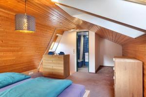 a room with two beds and a wooden wall at Maisonette auf 1000m mit Sauna in Schönwald