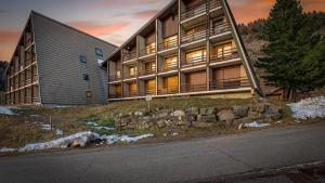 a building on a hill with a road in front of it at Studio 5 Pers, rdc, pied des pistes in Saint-Michel-de-Chaillol