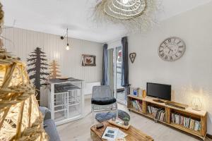 a living room with a tv and a clock on the wall at Studio 5 Pers, rdc, pied des pistes in Saint-Michel-de-Chaillol