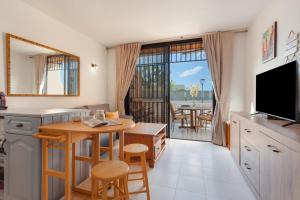 a kitchen and dining room with a table and a television at Casa Paradise Jannest in Adeje
