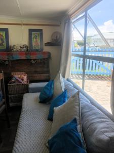 a living room with a couch with blue pillows at Kaalvoet Kaia in Stilbaai-Oos