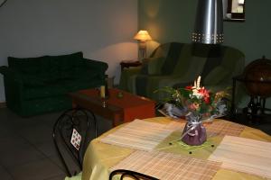 a living room with a table with a vase of flowers on it at Le Courtil De Bourrien in Languédias +4 photos