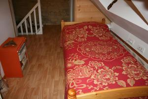 a bedroom with a bed with a red and gold blanket at Le Courtil De Bourrien in Languédias