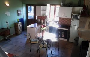 a kitchen with a table and chairs in a room at Le Courtil De Bourrien in Languédias