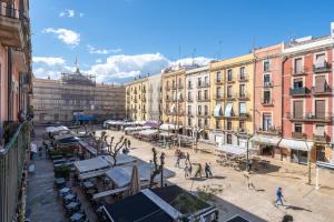 a city street with buildings and people walking around at Plaça la Font in Tarragona