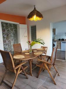 a dining room with a wooden table and chairs at Gîte KAZ' A TYKA jacuzzi privatif in Saint-François