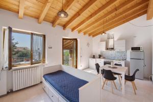 a bedroom with a bed and a table and a kitchen at Appartamenti Villafiorito in Lazise