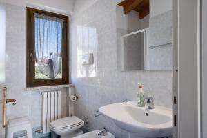 a bathroom with a sink and a toilet and a window at Appartamenti Villafiorito in Lazise +9 photos