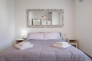 a bedroom with a bed with a mirror on the wall at Appartamenti Villafiorito in Lazise