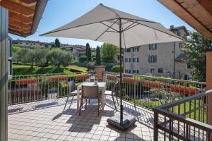 a patio with a table and an umbrella at Appartamenti Villafiorito in Lazise