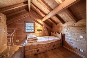 a bedroom in a log cabin with a bed in it at Chalet 6p Confort - Les Cerfs in Verchaix