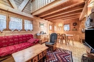 a living room with a red couch and a table at Chalet 6p Confort - Les Cerfs in Verchaix