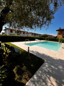 a swimming pool with a bench in a yard at Appartamenti Villafiorito in Lazise