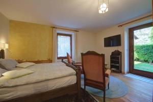 a bedroom with a bed and a chair and a window at Il Pellegrino in Issogne