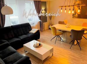 a living room with a couch and a table at Fewo Harzblick Goslar mit Pool in Goslar