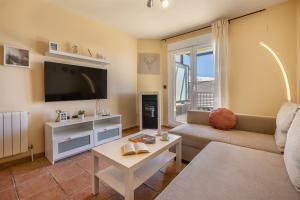 a living room with a couch and a tv at Alpine Sierra Nevada in Sierra Nevada