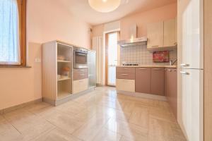 a kitchen with stainless steel appliances and a tile floor at Rosamare - Follonica in Follonica