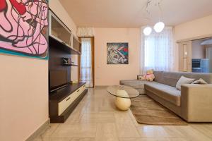 a living room with a couch and a tv at Rosamare - Follonica in Follonica