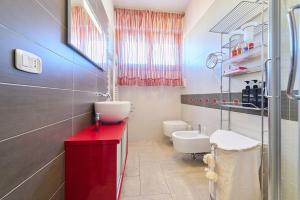 a bathroom with a red counter and a sink at Rosamare - Follonica in Follonica +23 photos