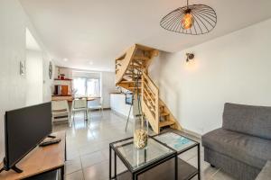 a living room with a couch and a staircase at Au Coeur De Plouguerneau in Plouguerneau