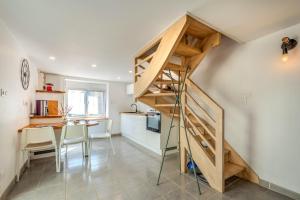 a staircase in a kitchen with a table and chairs at Au Coeur De Plouguerneau in Plouguerneau