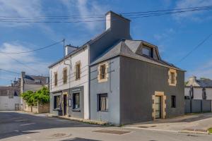 a white and black building on the side of a street at Au Coeur De Plouguerneau in Plouguerneau