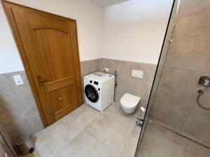 a bathroom with a washing machine and a toilet at Moderne Ferienwohnung Bodensee in Sigmarszell +2 photos
