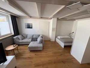 a living room with a couch and a bed at Moderne Ferienwohnung Bodensee in Sigmarszell