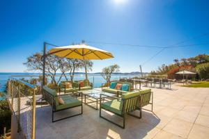 a patio with a table and chairs and an umbrella at Ventaou in Sainte-Maxime
