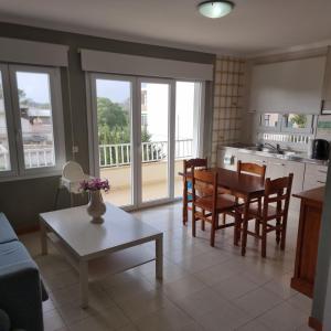 a kitchen and living room with a table and chairs at Apartamento Portosun Caracol in Portocolom