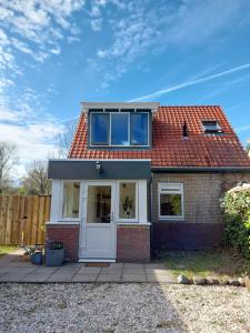 a small brick house with a white door at Het Gewei in Burgh Haamstede