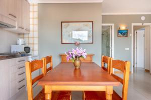 a dining room table with a vase of flowers on it at Apartamento Portosun Caracol in Portocolom