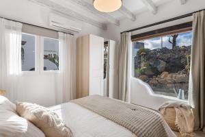 a bedroom with a bed and a large window at El Jable Rentals in Arrieta