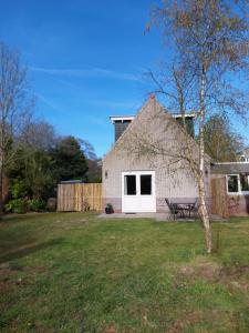 a house with a bench in a yard at Het Gewei in Burgh Haamstede