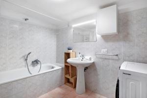 a white bathroom with a sink and a bath tub at Ca' Della Torre, a 5 min da Rialto in Venice +19 photos