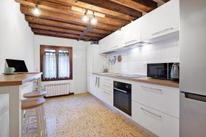 a kitchen with white appliances and a wooden ceiling at Ca' Della Torre, a 5 min da Rialto in Venice