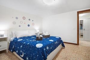 a bedroom with a bed with a blue blanket at Ca' Della Torre, a 5 min da Rialto in Venice