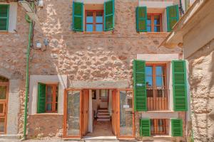 an old building with green shutters on it at Casa Antonia in Sóller