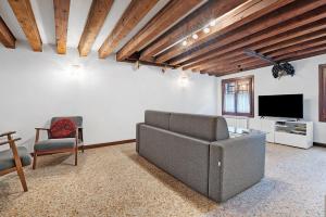 a living room with a couch and a tv at Ca' Della Torre, a 5 min da Rialto in Venice
