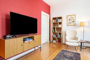 a living room with a flat screen tv on a red wall at Ferienwohnung Löwenstein in Hoya